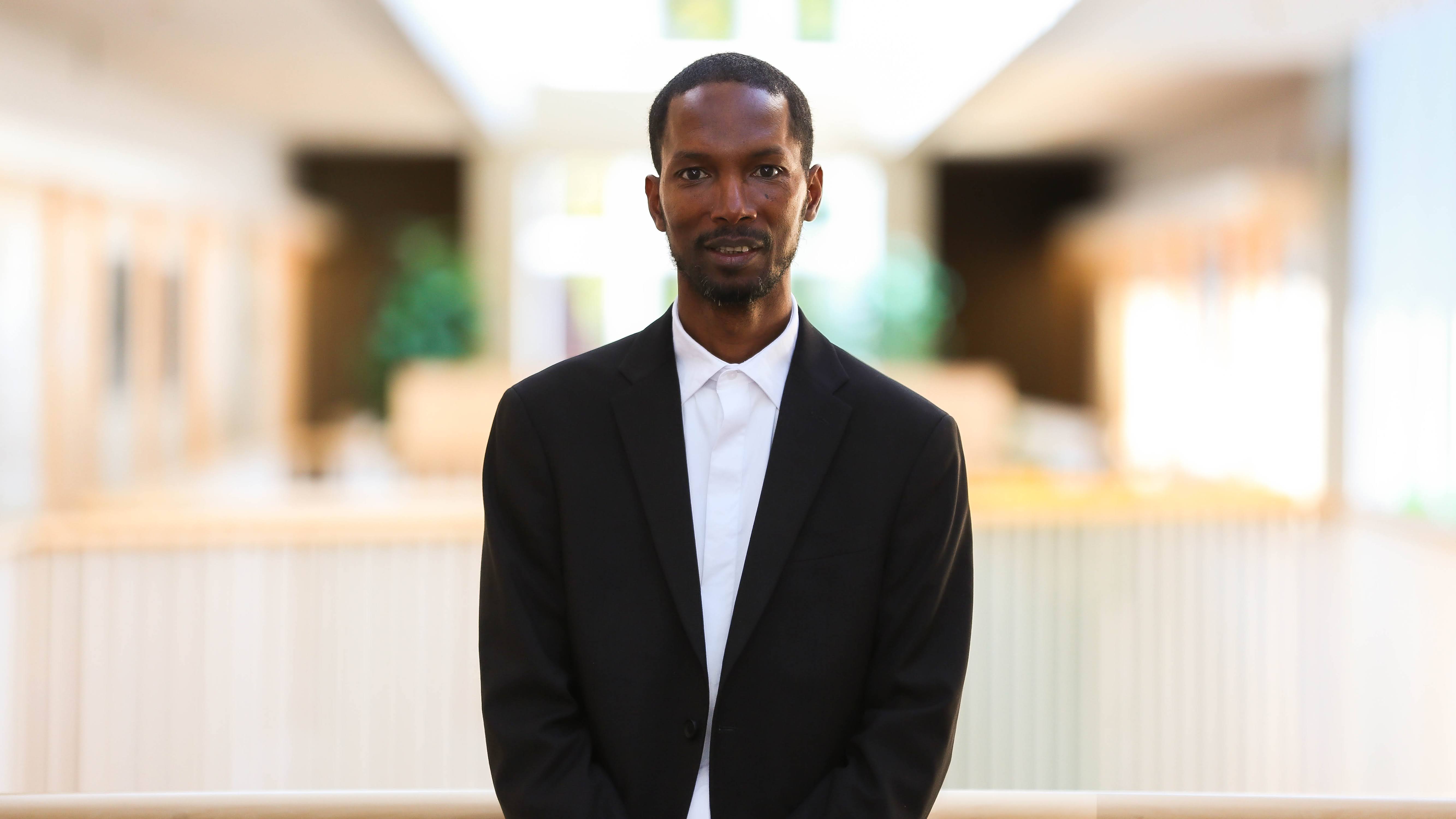 Chernoh Bah standing in a suit.